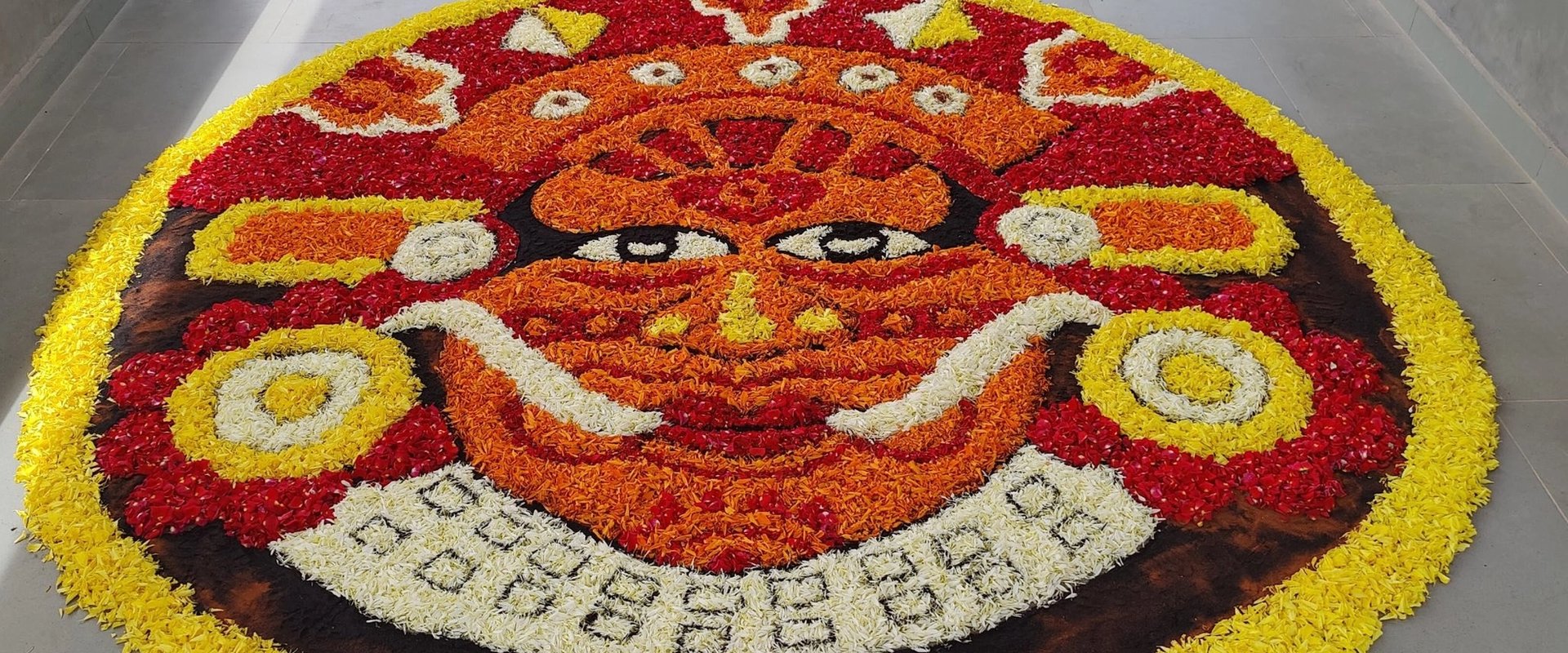 Colourful Onam pookalam floral design arranged on the floor